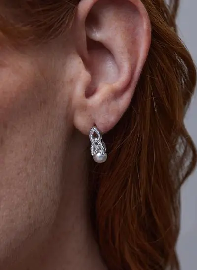 Close up shot of red haired model wearing Sterling Silver Trinity Knot Pearl Earrings with Swarovski Crystal